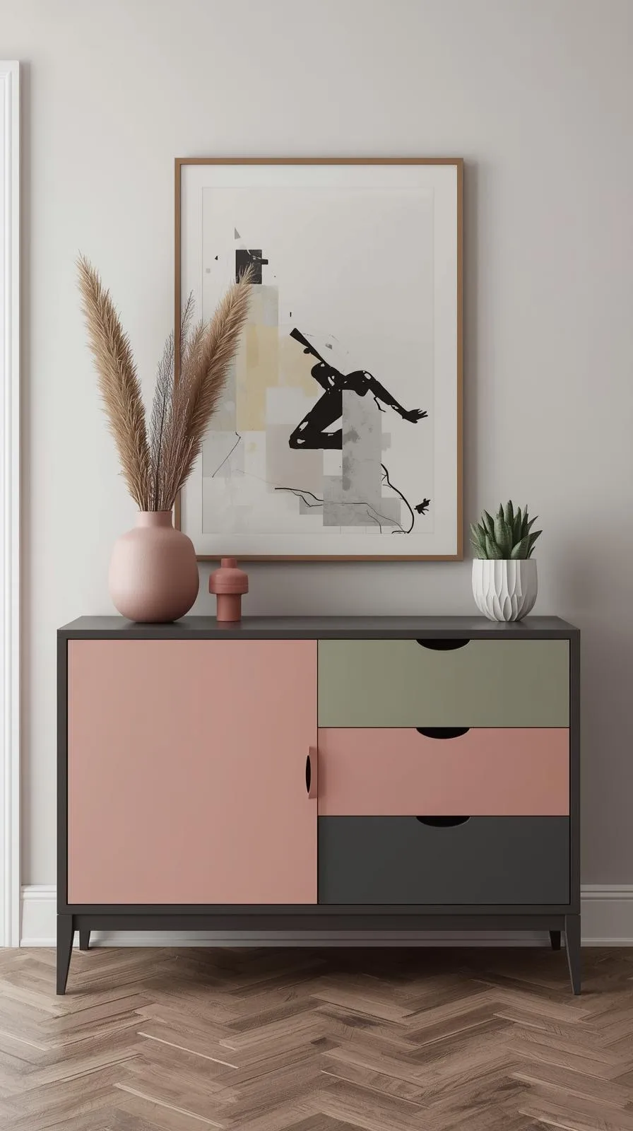 Un buffet d'entrée moderne de style "colorblock", avec une porte rose poudré et des tiroirs vert sauge et gris anthracite.