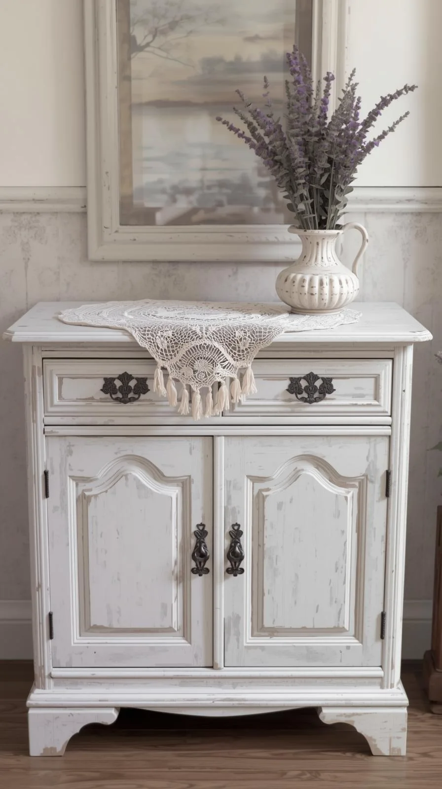 Un buffet d'entrée de style shabby chic, peint en blanc cassé avec un effet vieilli et des poignées vintage en métal.