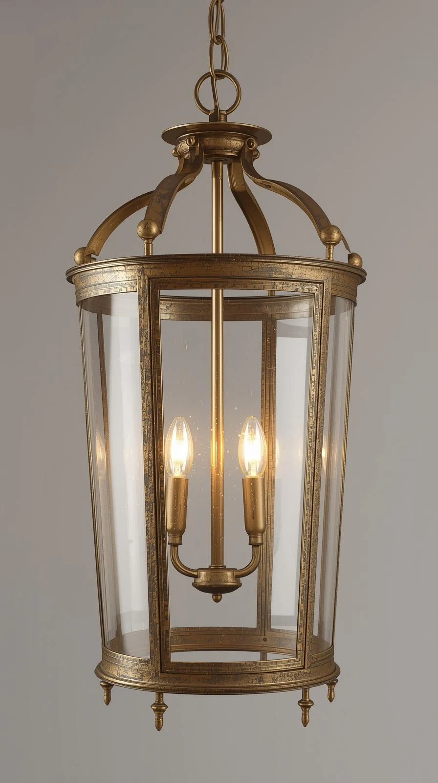 Un lustre lanterne de style classique en verre transparent et structure en laiton vieilli, avec des ampoules flamme.