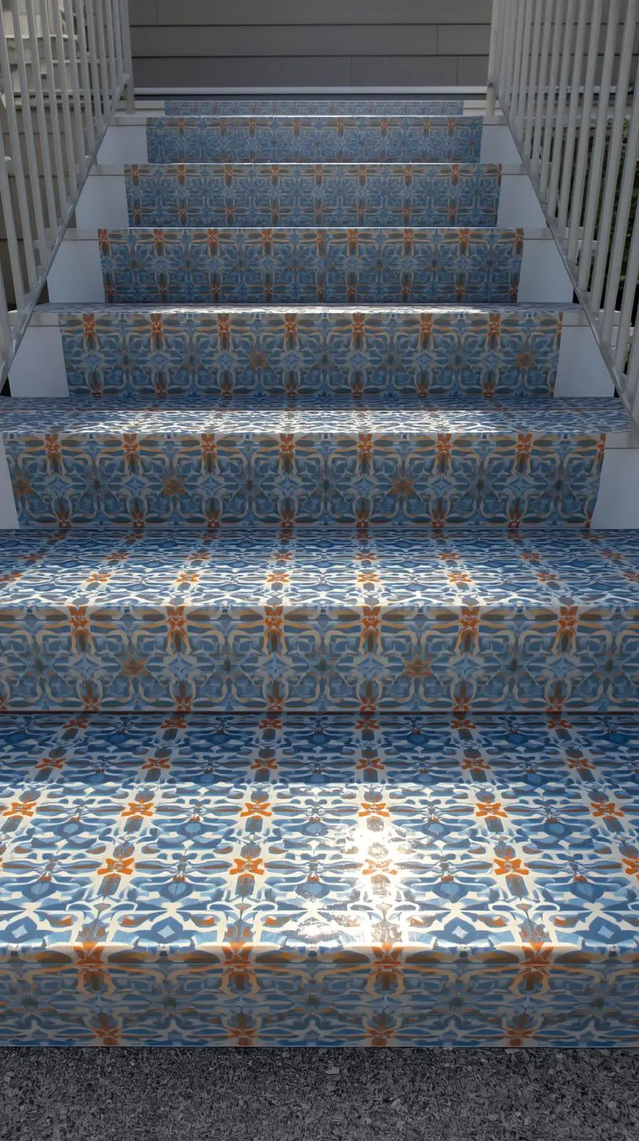 Un escalier extérieur dont les marches et contremarches sont entièrement recouvertes d'un adhésif ou de carreaux fins imitant des motifs de carreaux de ciment bleus et oranges.