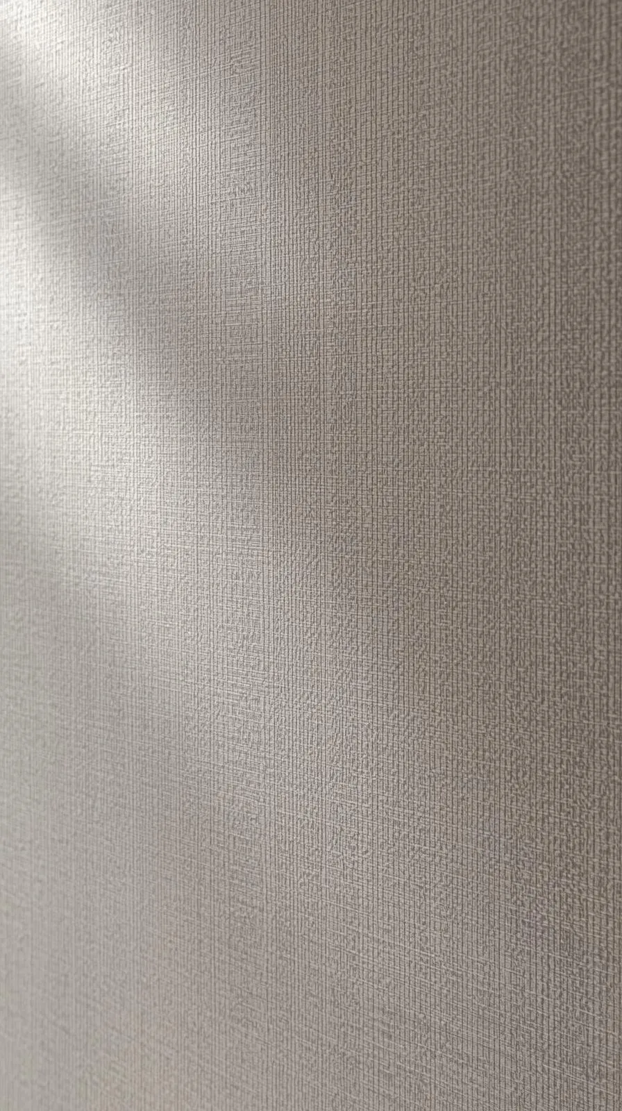 Gros plan en macro sur une tapisserie d'entrée unie, de couleur grise, avec une texture subtile effet lin ou tissu.