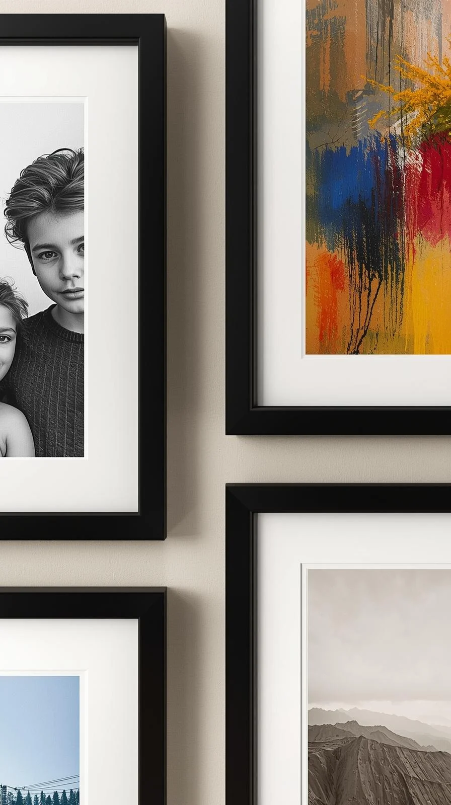 Détail d'un mur de galerie montrant un portrait d'enfant en noir et blanc à côté d'une reproduction d'art abstrait coloré.